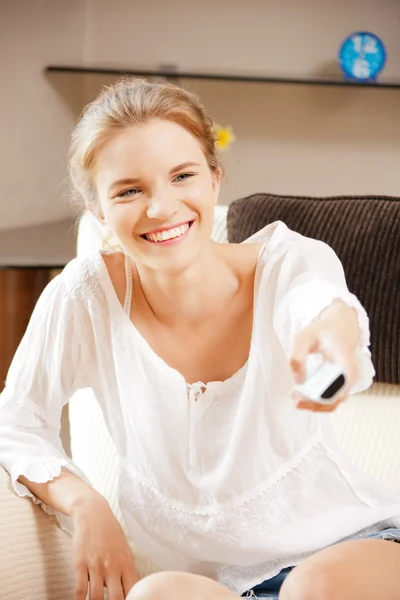 Happy teenage girl with TV remote — Stock Photo, Image