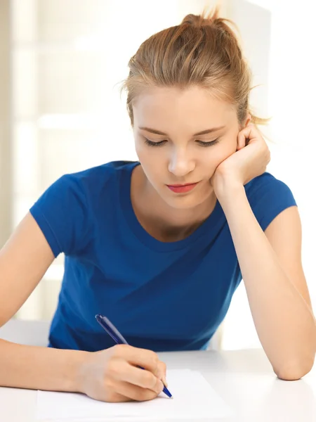 Fundersam tonårsflicka med papper och penna — Stockfoto