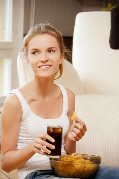 Lächelndes Teenager-Mädchen mit Chips und Cola — Stockfoto