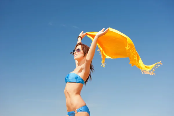 Mujer feliz con sarong amarillo en la playa — Foto de Stock