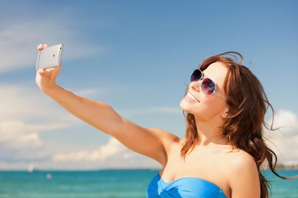 Gelukkige vrouw met telefoon op het strand — Stockfoto