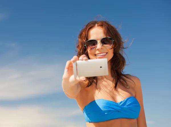 Glad kvinna med telefonen på stranden — Stockfoto