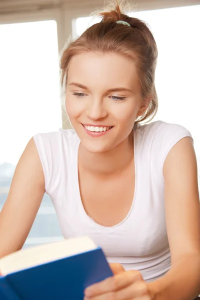 Счастливая и улыбающаяся девочка-подросток с книгой — стоковое фото