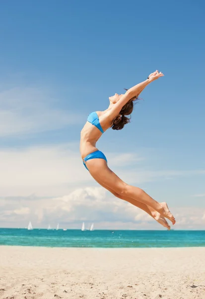 Счастливая прыгучая женщина на пляже — стоковое фото