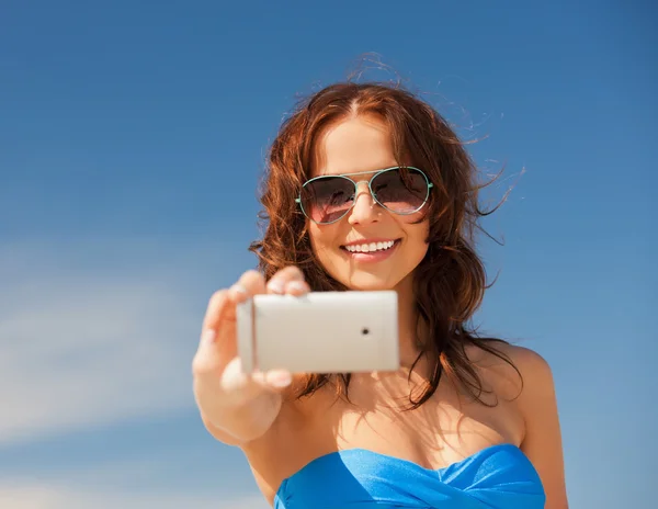 Счастливая улыбающаяся женщина с помощью камеры телефона — стоковое фото
