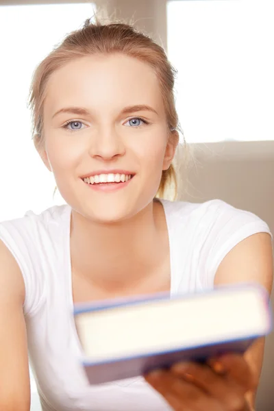 Счастливая и улыбающаяся девочка-подросток с книгой — стоковое фото
