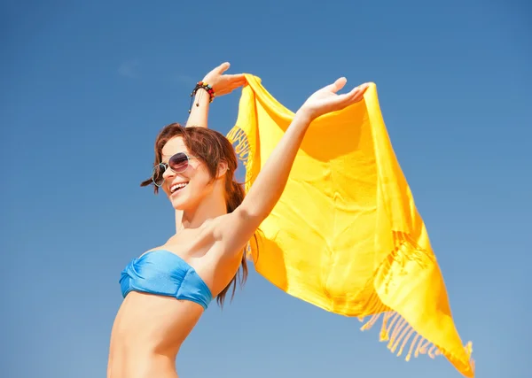 Счастливая женщина с желтым саронгом на пляже — стоковое фото