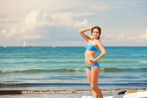 Счастливая женщина с виндсерфингом на пляже — стоковое фото