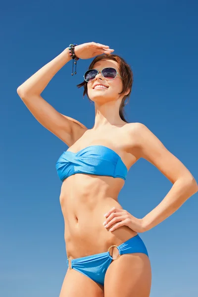 Gelukkige vrouw in zonnebril op het strand — Stockfoto