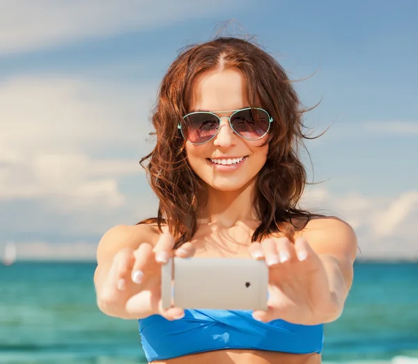 Šťastná žena s telefonem na pláži — Stock fotografie