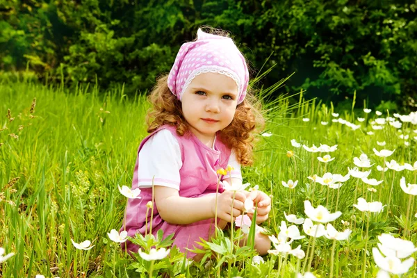 Girl among spring flowers — Stock Photo, Image