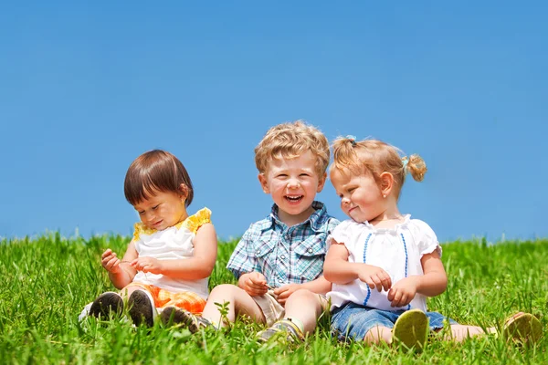 Děti sedět na trávě — Stock fotografie