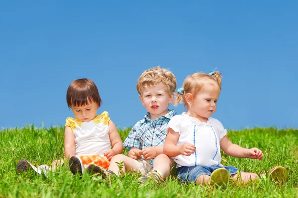 Děti sedět na trávě — Stock fotografie