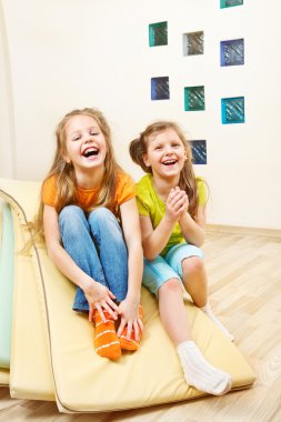 Girls sit on tumbling mats clipart