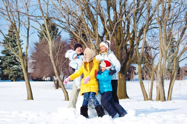 両親と雪の中で遊ぶ子供たち — ストック写真