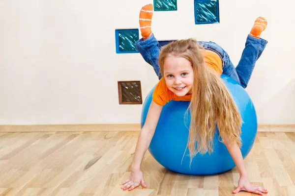 Девушка играет с гимнастическим мячом — стоковое фото