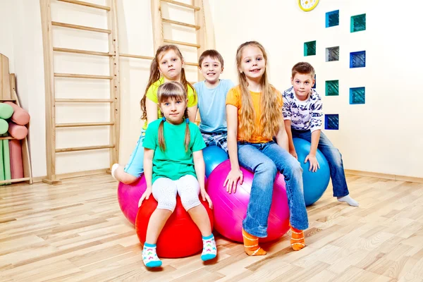 Children sitting on balls — Stock Photo, Image