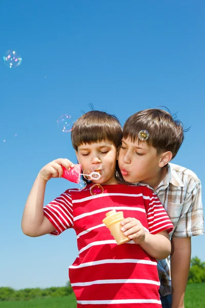 Boys blowing bubbles — Stock Photo, Image
