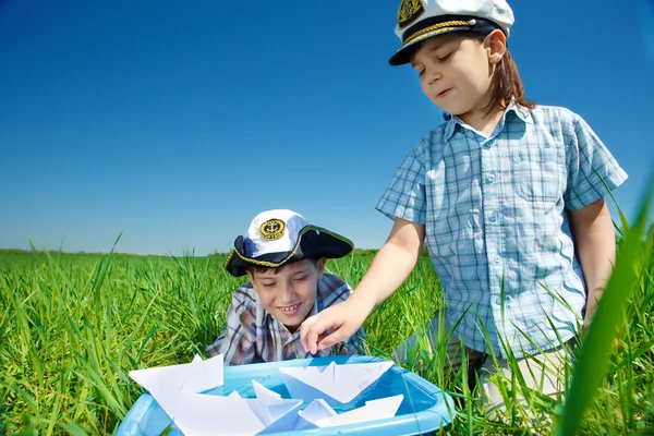Pojkar spelar med papper båtar — Stockfoto