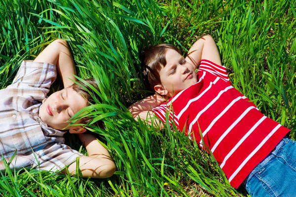 Dzieci leżąc na trawie — Zdjęcie stockowe