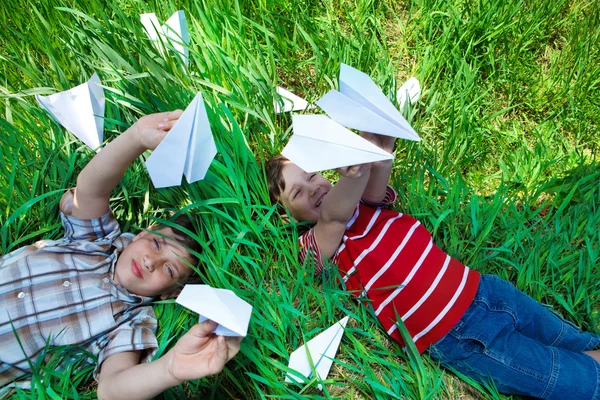 Leka med papper flygplan på gräs — Stockfoto