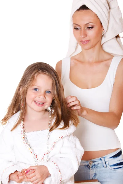 Uśmiechnięte dziewczyny i jej matka szczotkowanie włosów — Zdjęcie stockowe