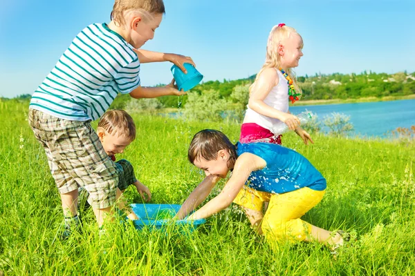 Niños en edad preescolar esparciendo agua — Foto de Stock
