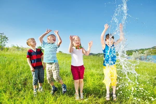 Barnen njuter av vattenstänk — Stockfoto