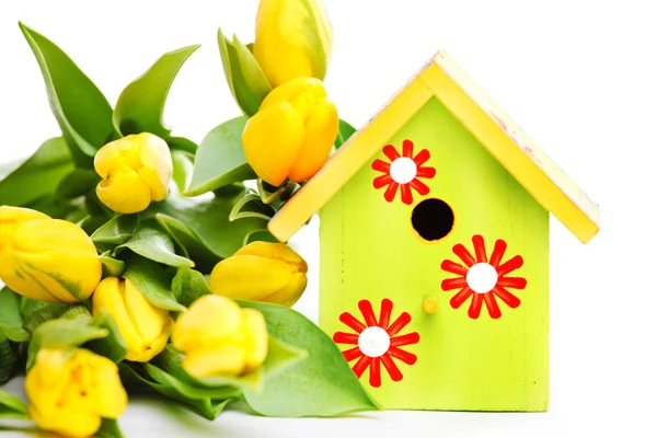 Vogel huis en gele bloemen — Stockfoto