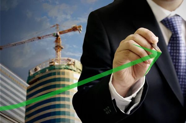 Podnikatel napsat rostou až zelená šipka s pozadím stránky stavební — Stock fotografie