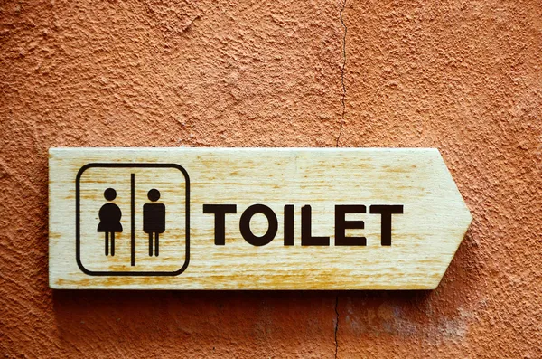 Toilet sign on color wall — Stock Photo, Image