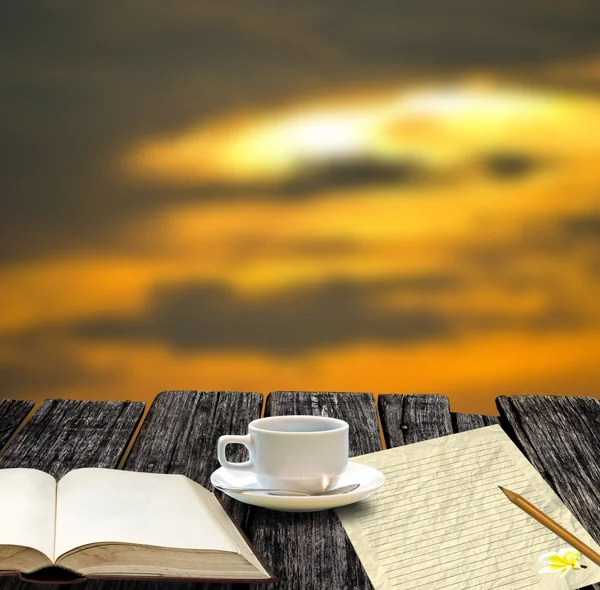 Кофейная чашка с чистой книгой и бумагой для заметок в утреннее время — стоковое фото