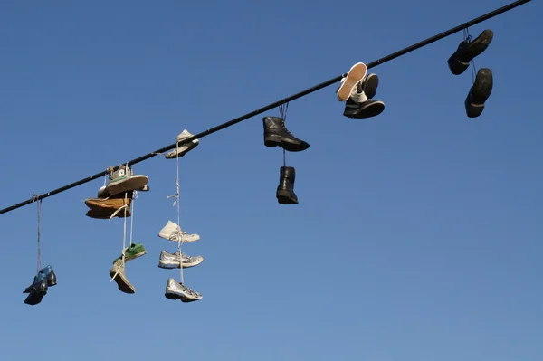 Shoes hanging on a cable — Stock Photo, Image