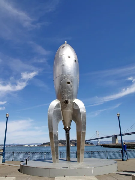 A temporary art installation, the Raygun Gothic Rocketship stands on a busy tourist promenade along the San Francisco Bay in San Francisco, California, USA — Stock Photo, Image