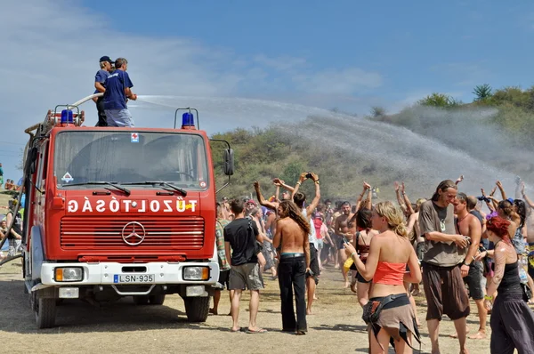 Fireman splashing water on the crowd on Ozora Festival — Stock Photo, Image