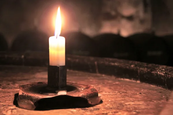 Burning candle in wine cellar — Stock Photo, Image