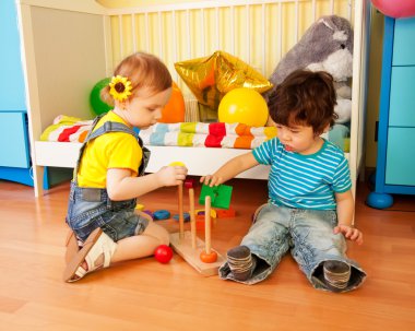 Boy and girl playing with toy pyramid puzzle clipart