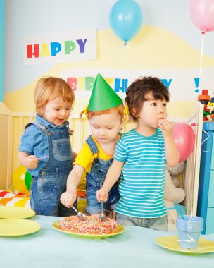 Three kids eating cake on the birthday party clipart