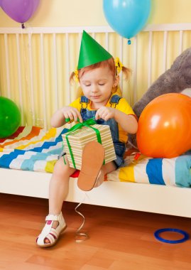 Little girl opening the present clipart