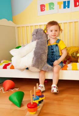 Girl sitting in the baby bed with boys clipart