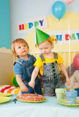 Two kids eating cake on the birthday party clipart