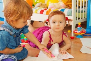 Boy and girl drawing with crayons clipart