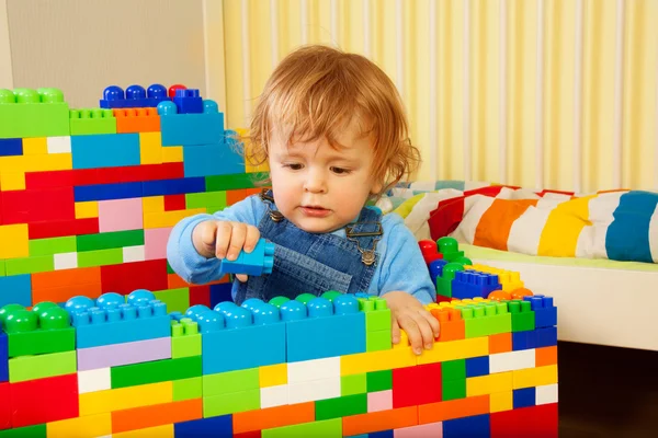 Маленький хлопчик грає з пластиковими блоками — стокове фото
