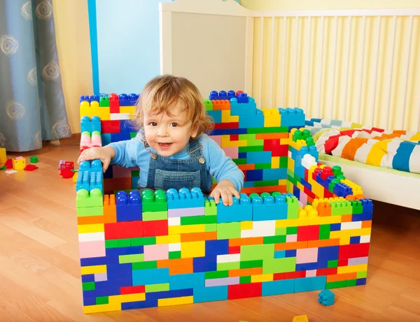 Тодлер сидить у замку іграшкових блоків — стокове фото