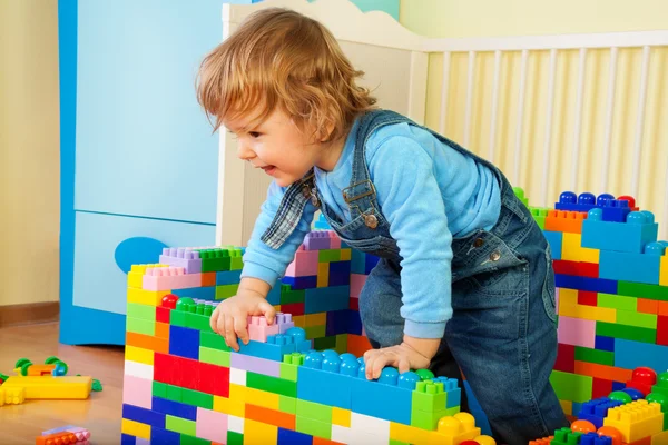 Щаслива дитина, що стверджує з іграшкового блоку — стокове фото