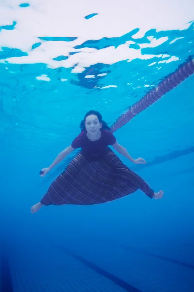 Donna che nuota in piscina in vestiti — Foto Stock