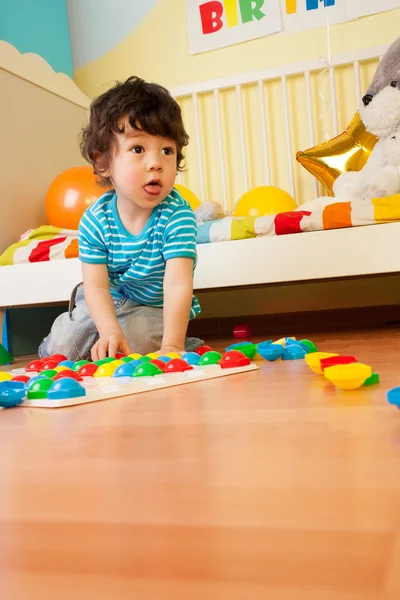 Mrňavá chlapec hraje s mozaikou — Stock fotografie