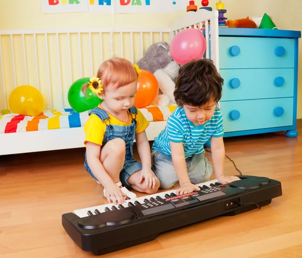 Мальчик и девочка играют на музыкальном инструменте — стоковое фото