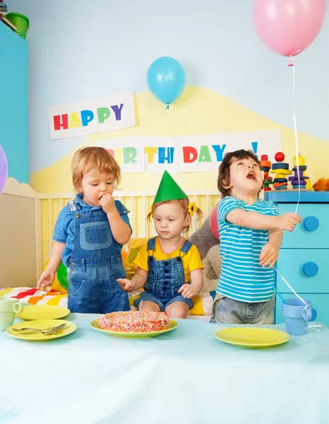 Três crianças comendo bolo de aniversário — Fotografia de Stock
