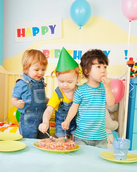 Tři děti jíst dort na narozeninovou oslavu — Stock fotografie